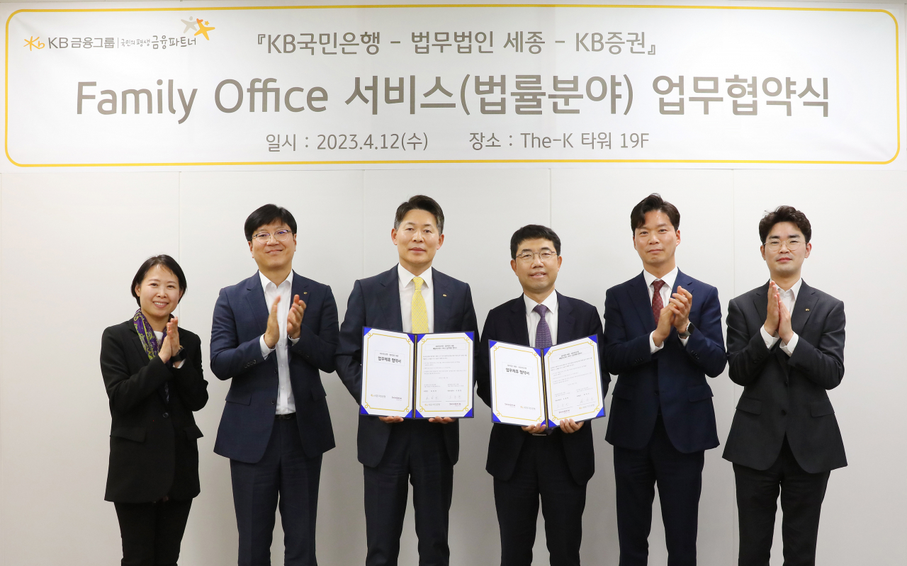 Third from left: KB Financial Group’s Wealth Management and Pension Senior Managing Director Choi Jae-young, Shin&Kim’s Managing Partner Oh Jong-han and Shin&Kim's Partner Kim Hyeon-jin pose for a photo after signing a memorandum of understanding to offer legal consulting services in Seoul, Wednesday. (KB Financial Group)