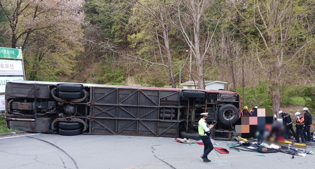 A tour bus falls on its side in Chungju, North Chungcheong Province, on April 13, 2023, in this photo provided by North Chungcheong Province Fire Station. (Yonhap)