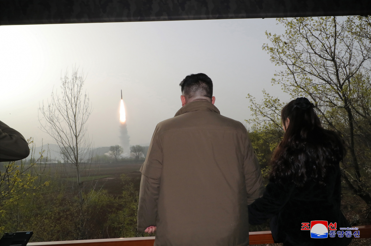 This photo, provided by North Korea's official Korean Central News Agency on April 14, 2023, shows North Korean leader Kim Jong-un and his daughter Ju-ae observing the test-firing of the North's new solid-fuel Hwasong-18 intercontinental ballistic missile the previous day. (Yonhap)