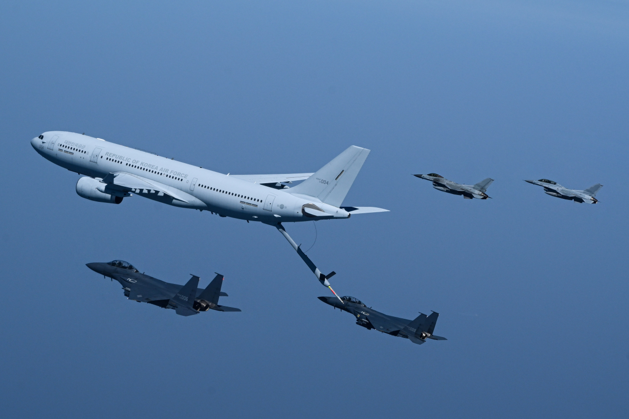 A KC-330 aerial tanker of the South Korean Air Force refuels an F-15K fighter jet through a retractable pipeline in midair while flying closely at the same speed over the West Sea on the Korean Peninsula on Wednesday. Two F-15K fighter jets (left) and two KF-16 fighter aircraft fly parallel to the KC-330. (Republic of Korea Air Force)