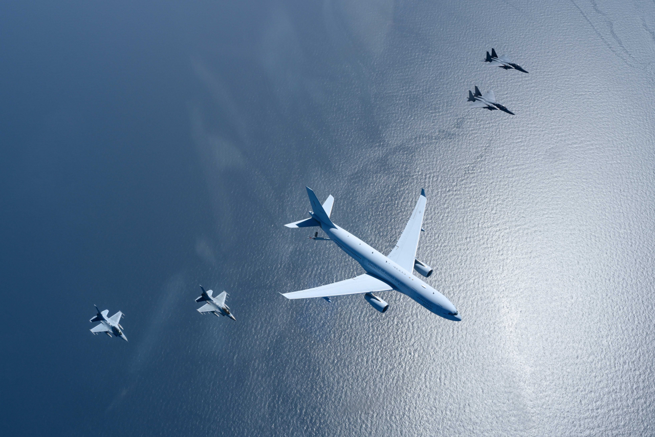 A KC-330 aerial tanker (center) of the South Korean Air Force flies alongside two F-15K (left) and KF-16 fighter jets (right) over the West Sea during an air-to-air refueling exercise on April 12. (Republic of Korea Air Force)
