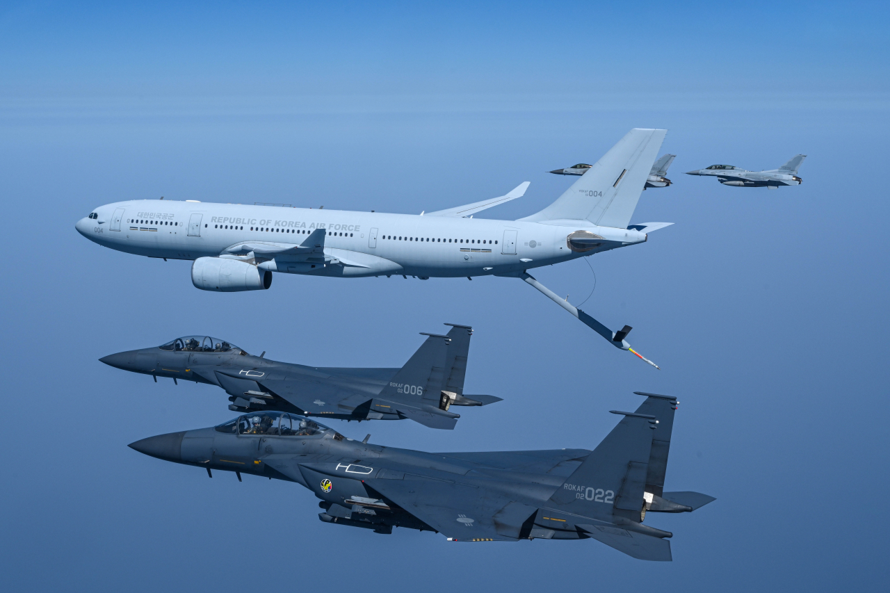 A KC-330 aerial tanker (center) of the South Korean Air Force extends a retractable pipeline, dubbed a 