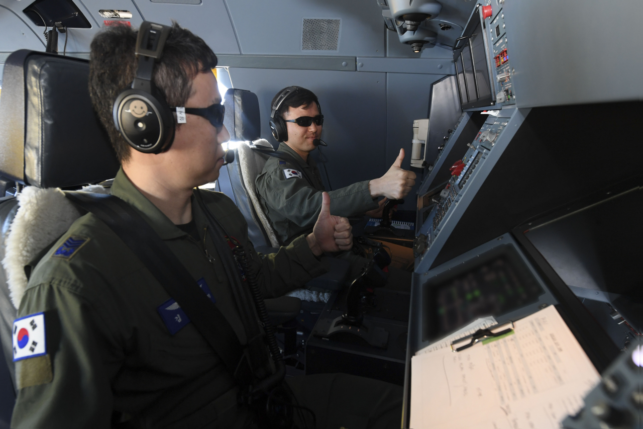 In-flight refueling specialists give a thumbs-up to each other after completing their aerial refueling mission on April 12. (Republic of Korea Air Force)