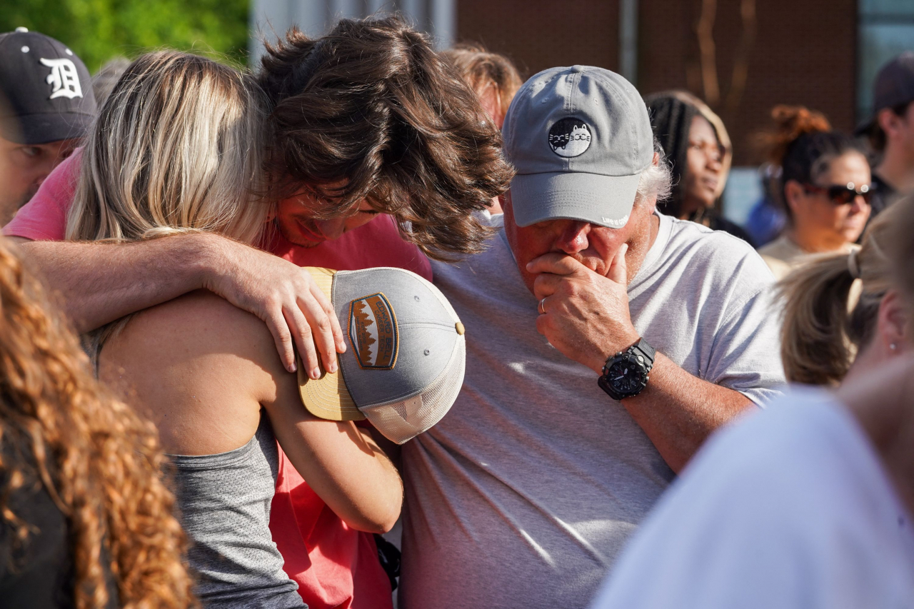 Mourners embrace each other during a vigil the day after a shooting during a teenager's birthday party at Mahogany Masterpiece Dance Studio in Dadeville, Alabama, Sunday. (AFP-Yonhap)