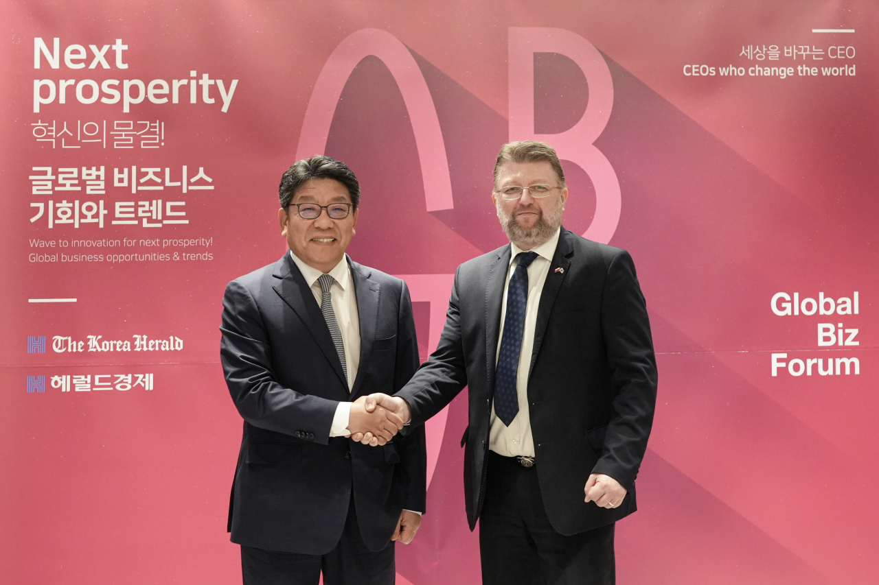 Polish Ambassador to Korea Piotr Ostaszewski (right) and The Korea Herald CEO Choi Jin-young exchange greetings at the third edition of the Global Business Forum hosted by The Korea Herald at the Ambassador Seoul hotel in Jung-gu, Seoul, Wednesday. (Damdastudio)