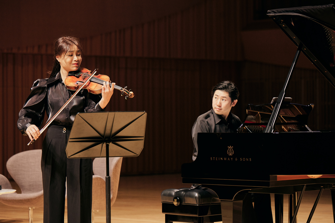 Violinist Yoon So-young (left) and pianist Lee Jin-sang perform together during a press conference held at the Lotte Concert Hall in Seoul, Tuesday. (Lotte Concert Hall)