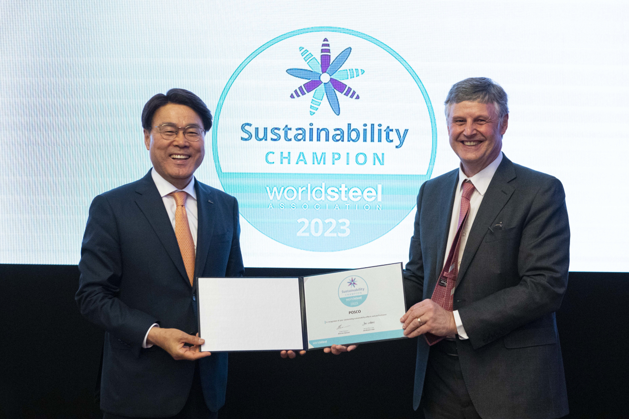 Posco Chairman Choi Jeong-woo (left) and Edwin Basson, director general of the World Steel Association, pose for a photo after a sustainability champion awarding ceremony held in Vienna, last week. (Posco Group)
