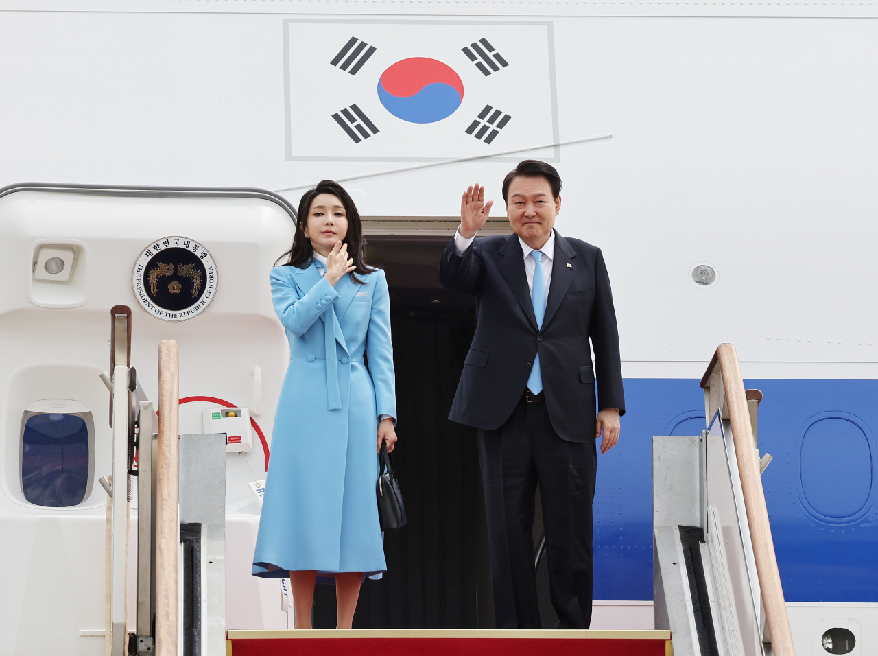 President Yoon Suk Yeol and first lady Kim Keon Hee wave before leaving for Washington D.C. at Seongnam Air Base, Gyeonggi Province, on Monday. (Yonhap)