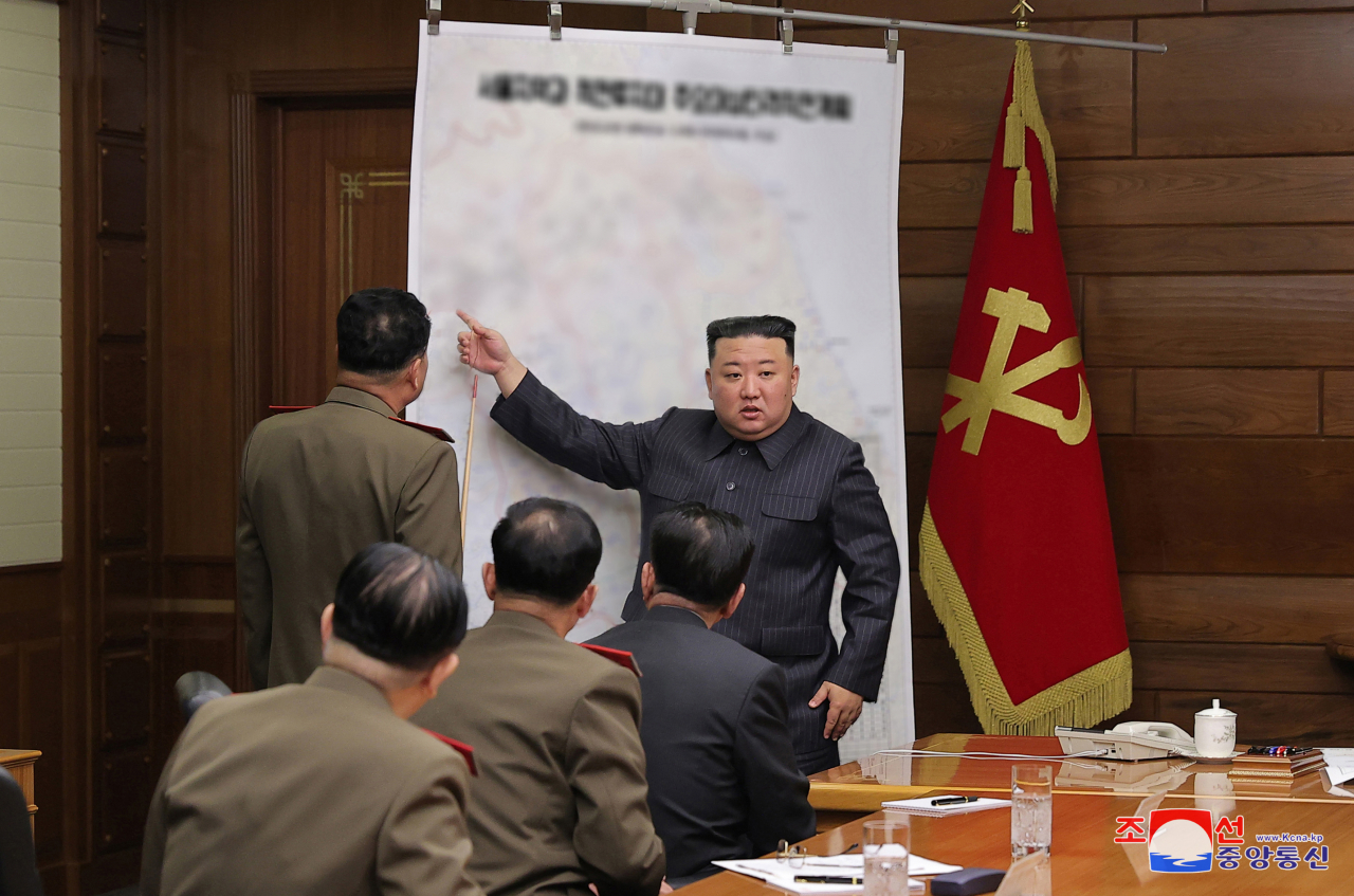 North Korean leader Kim Jong-un (standing, right) speaks during a meeting of the central military commission of the ruling Workers' Party on April 10, 2023, in this photo provided by the North's official Korean Central News Agency. (Yonhap)