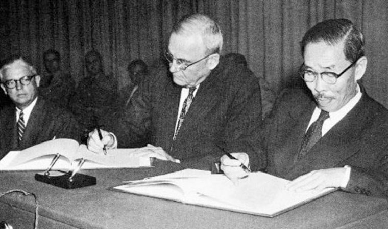 South Korea's Foreign Minister Byun Young-tae, right, and US Secretary of State John Dulles sign a provisional Mutual Defense Treaty in Seoul on August 8, 1953. (National Archives of Korea)