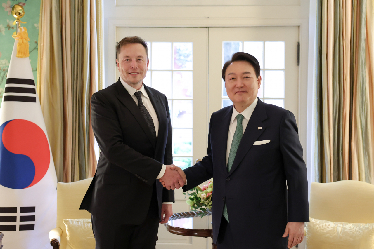President Yoon Suk Yeol (right) and Tesla CEO Elon Musk shake hands before talks at Blair House, across the street from the White House, in Washington on Wednesday. (Joint Press Corps)