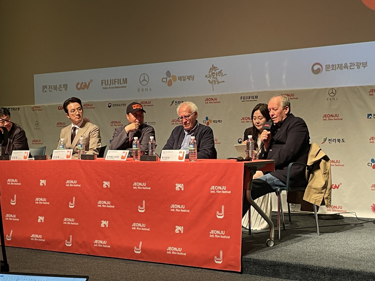 Luc Dardenne (right) and Jean-Pierre Dardenne (third from right) speak to reporters during a press conference for their film, “Tori and Lokita,” held at the Jeonju Cine Complex on Thursday. (Kim Da-sol/The Korea Herald)