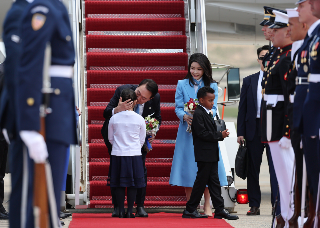 This photo shows President Yoon Suk Yeol and first lady Kim Keon Hee greeted by children holding flower bundles at Joint Base Andrews in Maryland, US on Monday. (Yonhap)