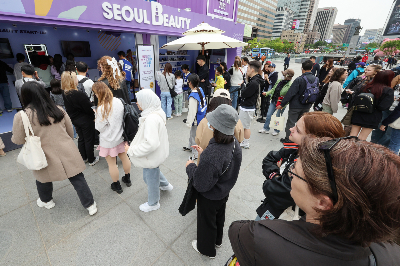 Foreign visitors line up at the “K-Beauty Zone” at the Gwanghwamun Plaza in central Seoul, the main venue of “Seoul Festa 2023” on Sunday. (Yonhap)