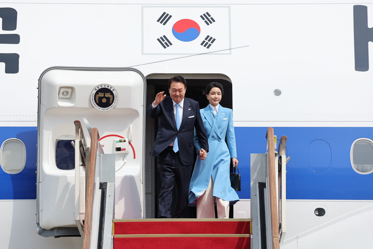 President Yoon Suk Yeol (left) waves at Seoul Air Base in Seongnam, Gyeonggi Province, Sunday, alongside his wife Kim Keon Hee as they return from a state visit to the US. (Yonhap)