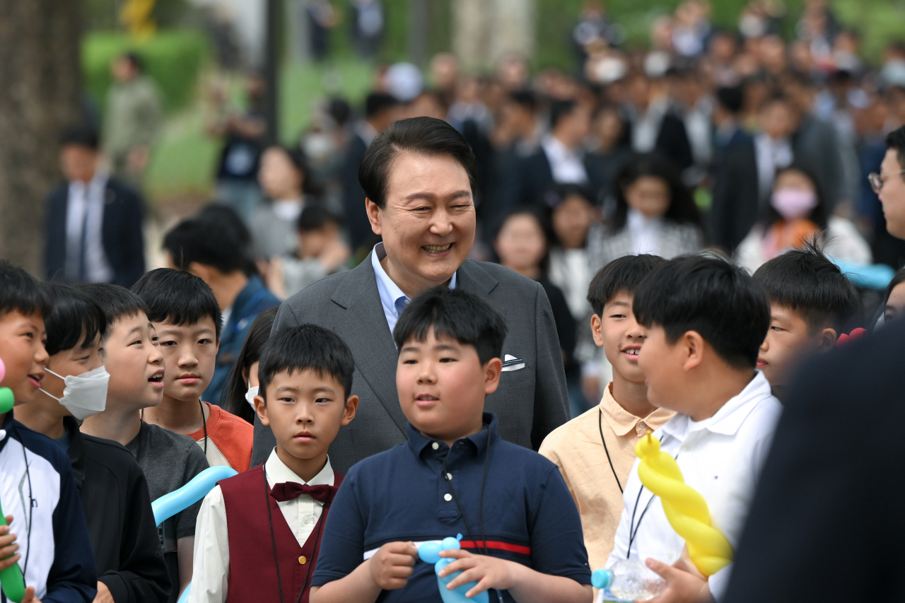 President Yoon Suk Yeol smiles brightly with children at the Yongsan Children's Garden opening ceremony in the front yard of the presidential office in Yongsan, Seoul on Thursday. (Yonhap)