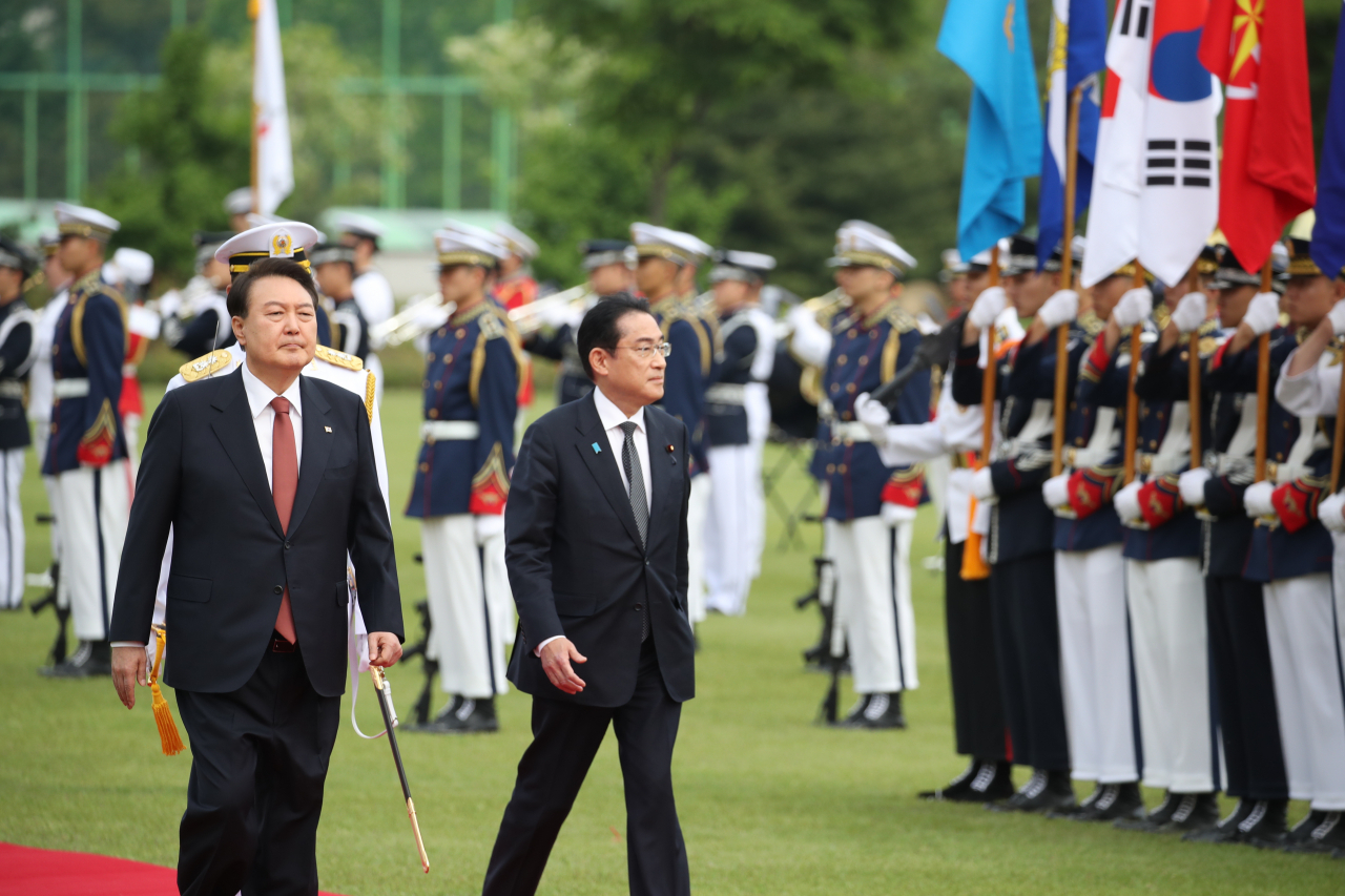 President Yoon Suk Yeol and Japanese Prime Minister Fumio Kishida review the honor guard at an official welcome ceremony held at the presidential office in Yongsan, Seoul on Sunday. (Yonhap)