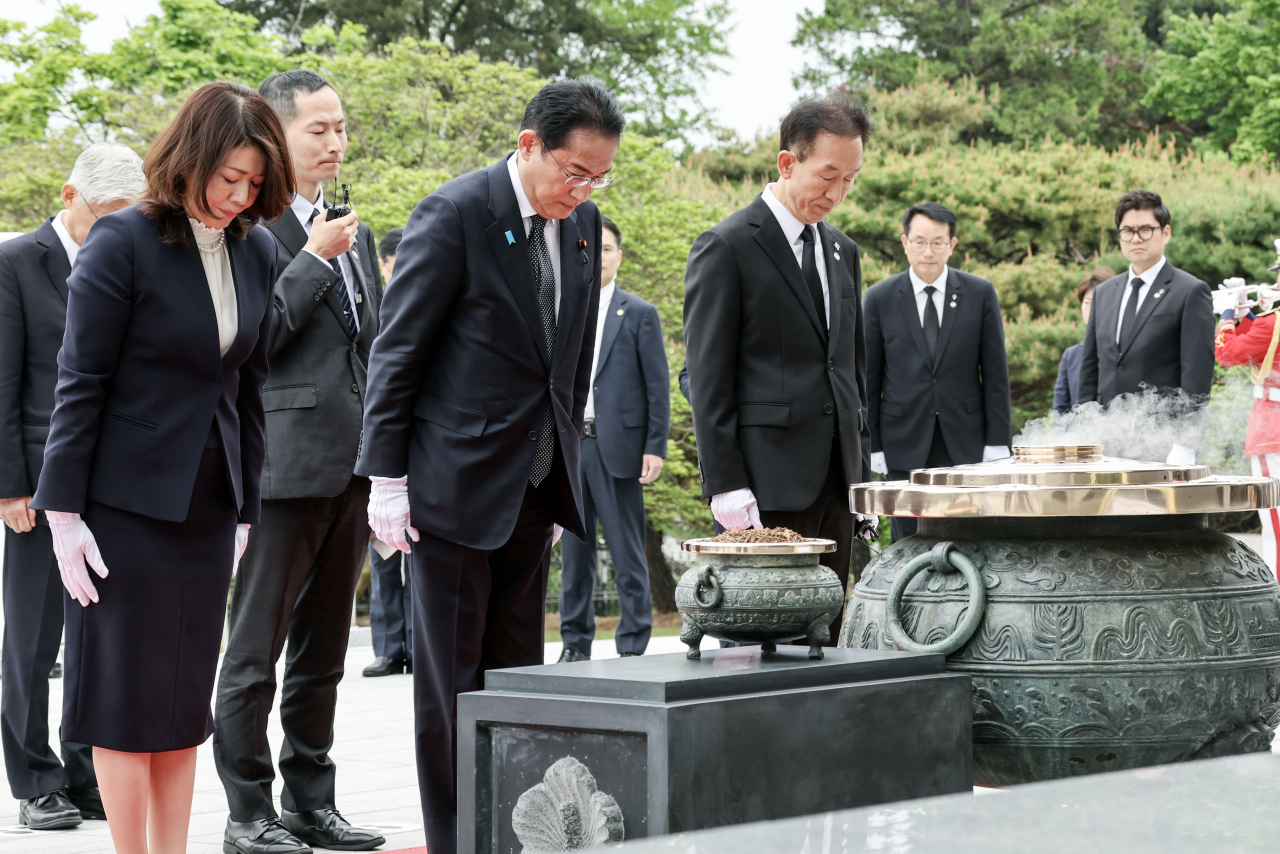Japanese Prime Minister Fumio Kishida (front second from left) and his wife, Yuko (front left), pay silent tribute to South Korean patriotic martyrs and war dead at the National Cemetery in Seoul on Sunday. (Yonhap)