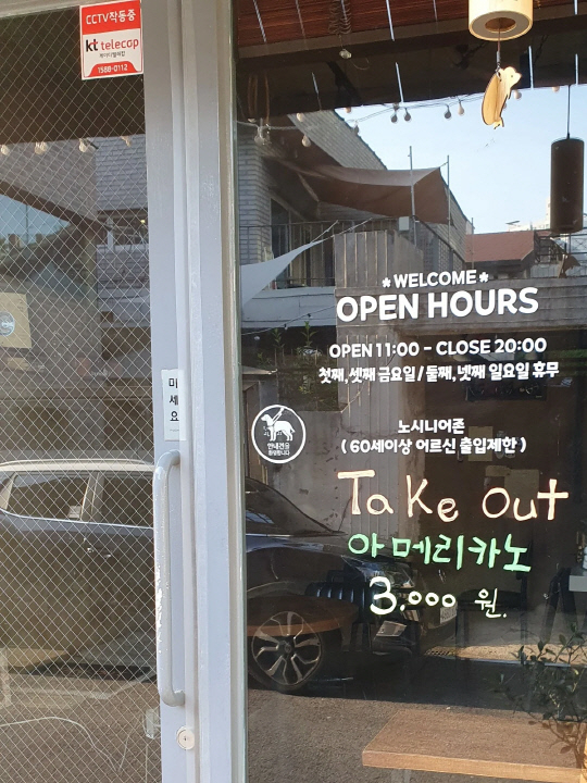 A cafe door has text that reads: 