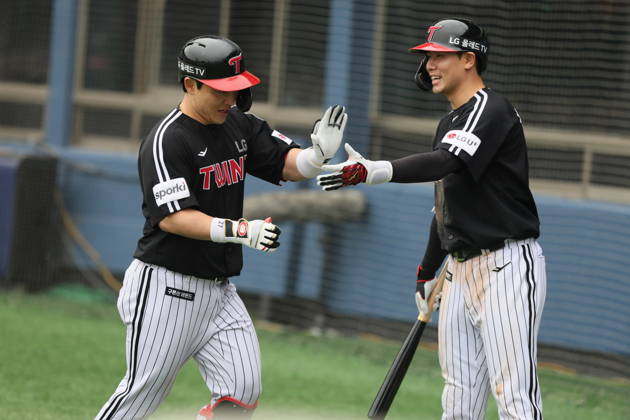 Park Dong-won of the LG Twins (left) high-fives teammate Hong Chang-ki after hitting a two-run home run against the Doosan Bears during the top of the fifth inning of a Korea Baseball Organization regular season game at Jamsil Baseball Stadium in Seoul on Sunday (LG Twins)