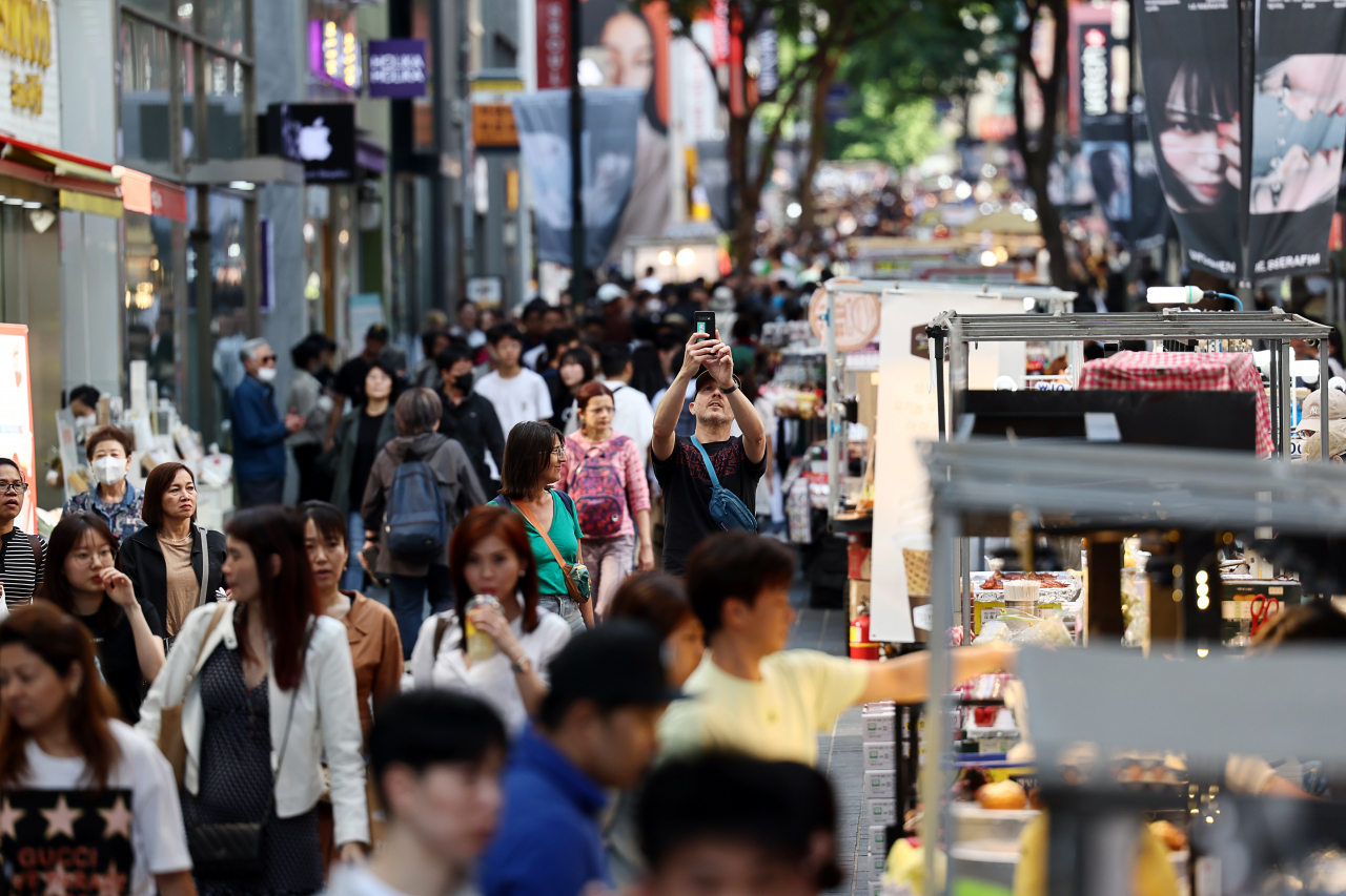 The central shopping district of Myeongdong, Seoul, is busy with visitors last Sunday. (Yonhap)