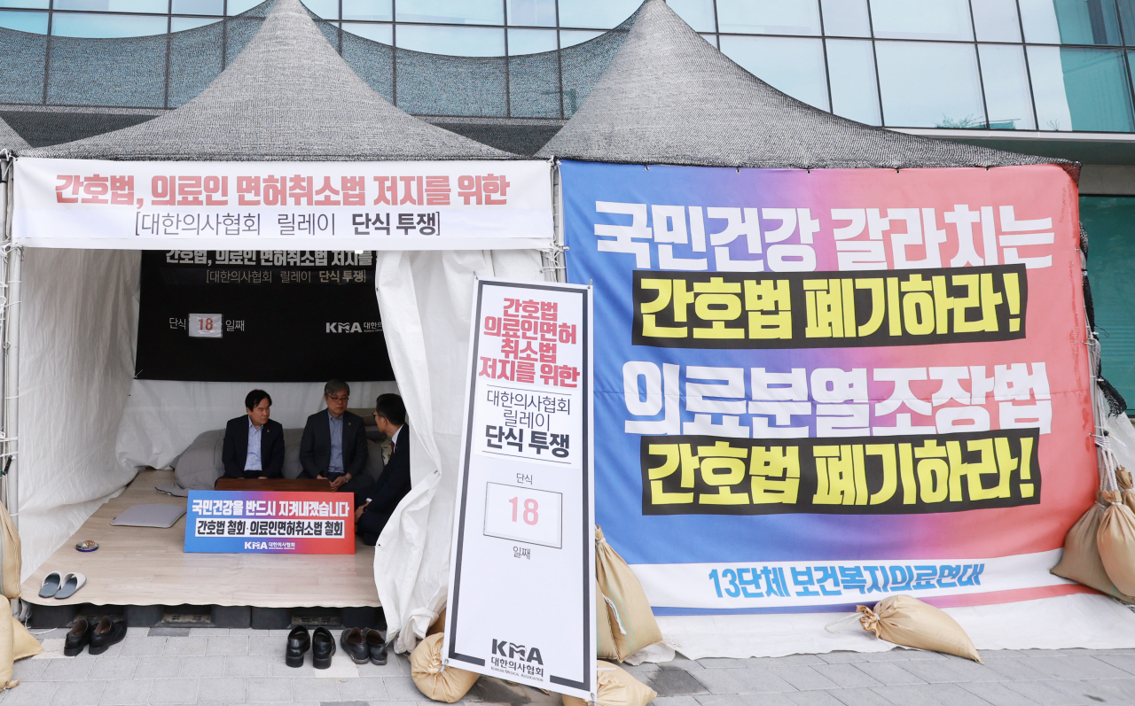 Lee Pil-soo (right), president of the Korean Medical Association, talks with Lee Gwang-rae (left), president of the National Council of Provincial Medical Associations, and Kim Tae-jin, president of the Busan Metropolitan City Medical Association, who participate in a relay fasting sit-in at a tent farm in front of the Korean Medical Association in Yongsan, Seoul, on May 14. (Yonhap)