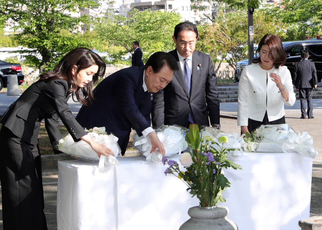 President Yoon Suk Yeol (second from left) and first lady Kim Keon Hee, Japanese Prime Minister Fumio Kishida (second from right) and first lady Kishida, lay a wreath at the memorial for Korean atomic bomb victims in Hiroshima Peace Memorial Park on Sunday. (Yonhap)