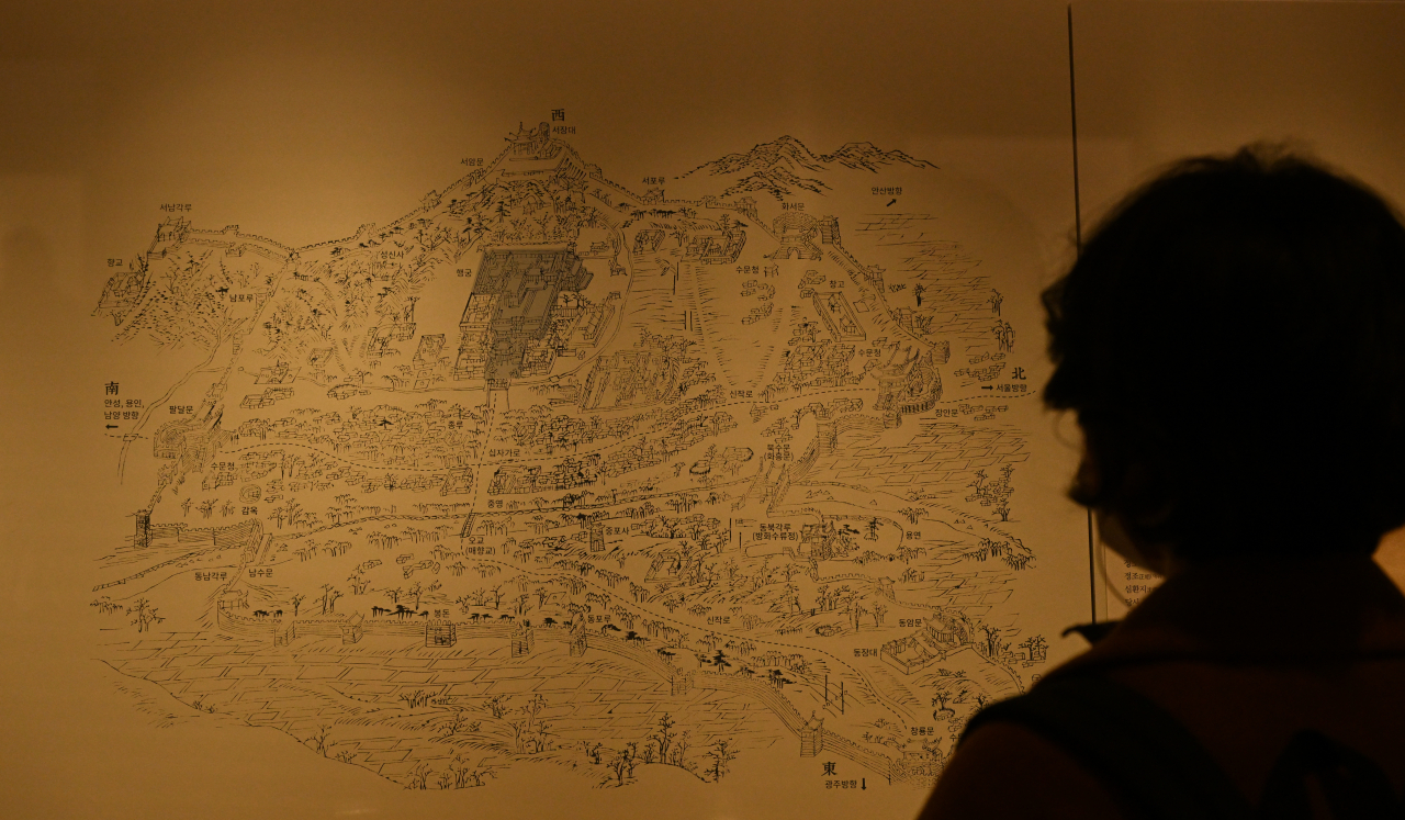 A visitor looks at the complete map of the Hwaseong fortress, through a copied page from the “Hwaseong Seongyeok Uigwe