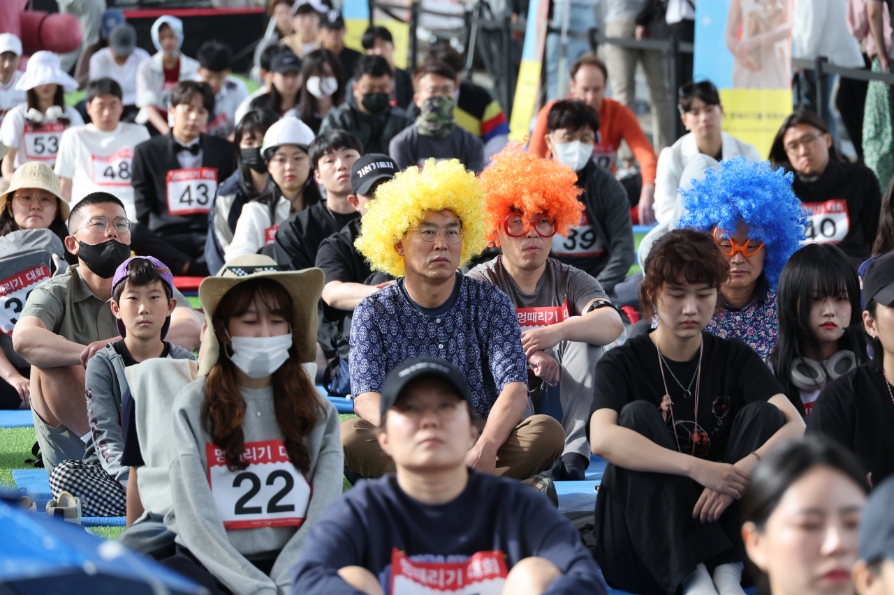 Participants try to keep a straight face during the annual Hangang Space-out Competition, held at Jamsoo Bridge over Seoul's Han River on Sunday. (Yonhap)
