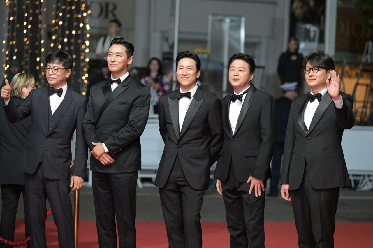 “Project Silence” cast members including Lee Sun-kyun (center) and Ju Ji-hoon (second from left) pose for photos at a red carpet event at the Lumiere Theater in Cannes, France, Sunday. (CJ ENM)
