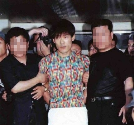 This photo shows Sin Chang-won (center) who was caught after more than 2 years of escape from prison in 1999. (Herald DB)