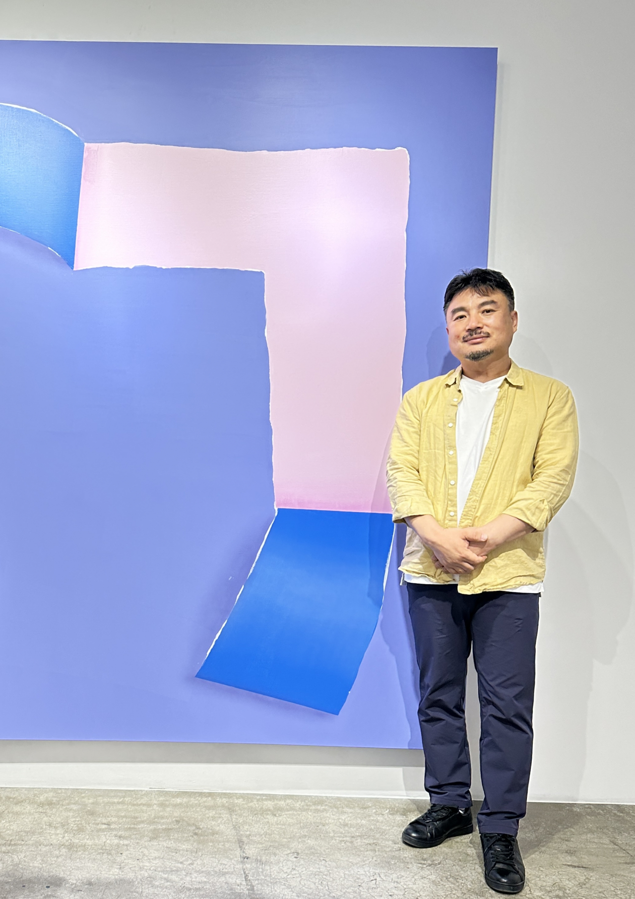 Kim Bo-seong poses for a photo with his painting 