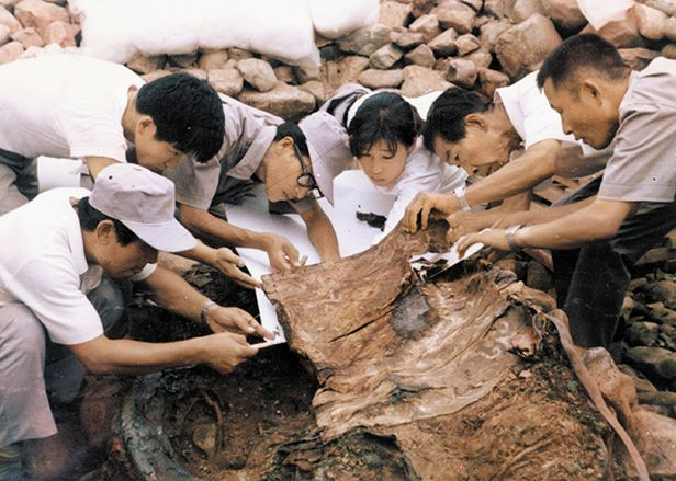 Field researchers, including Choi Byung-hyun (third from left) and So Seong-ok (third from right) examine Cheonmado at the excavation site of Cheonmachong in 1973. (Gyeongju National Research Institute of Cultural Heritage)