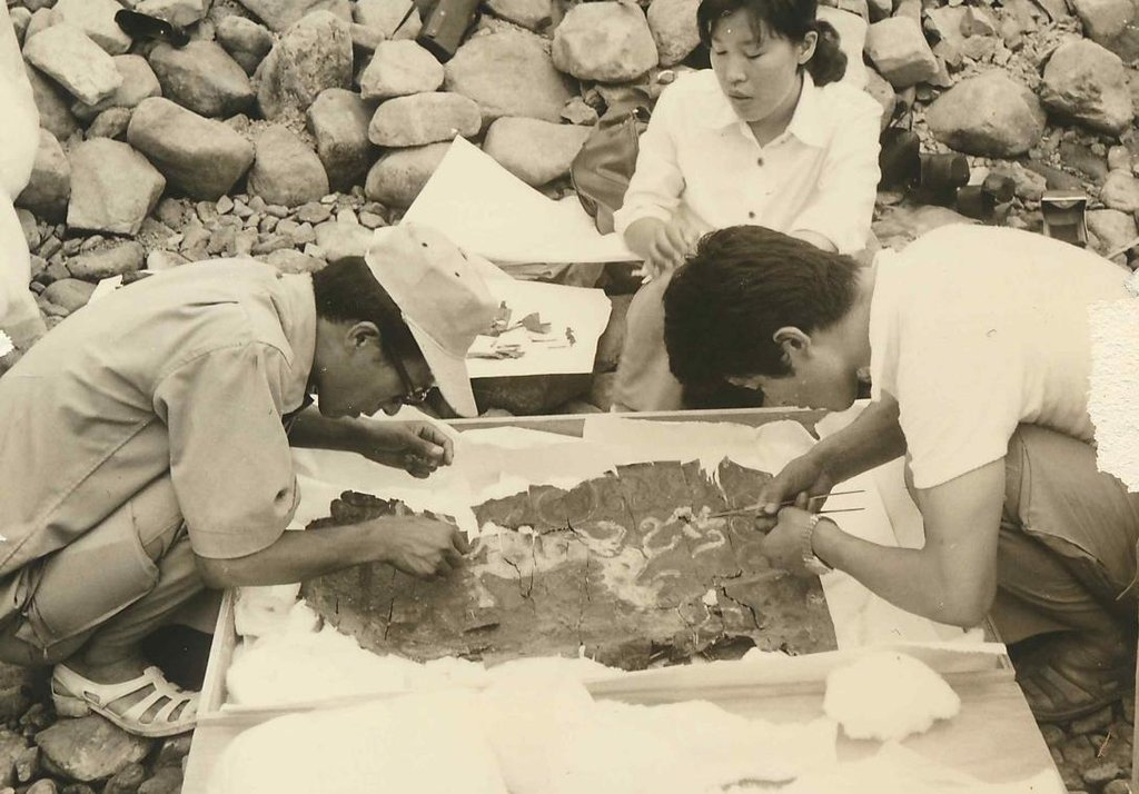 Choi Byung-hyun (left) works on the unearthed Cheonmado, which was drawn on a mudguard flap made of birch bark, between the 5th and 6th century AD. (Cultural Heritage Administration)