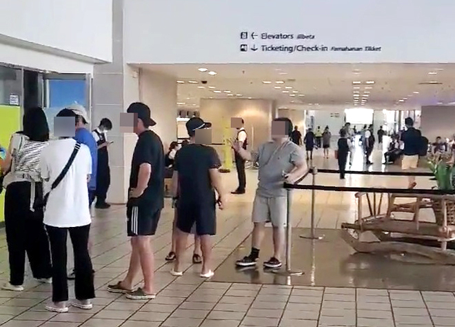 Stranded tourists at Guam international airport on Monday waiting in line to get on plane to return home (Yonhap)