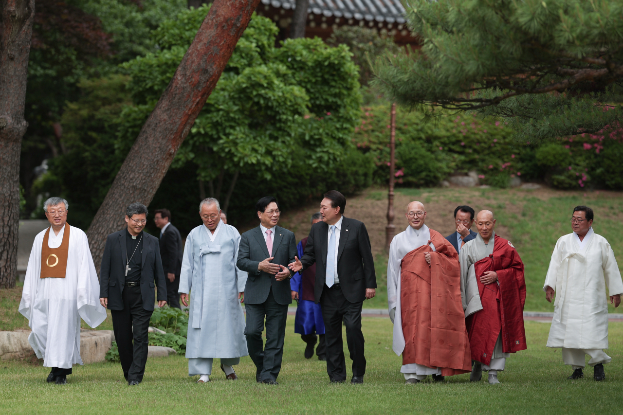 President Yoon Suk Yeol (fifth from left) walks with religious leaders after a luncheon with them at the former presidential compound of Cheong Wa Dae in Seoul on May 30, 2023, in this photo provided by the presidential office. (Yonhap)