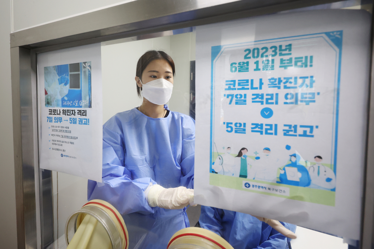 A medical worker puts up a notice that notifies the mandatory isolation period will be reduced to five days as a recommendation, from the seven-day requirement, starting June 1 at a COVID-19 treatment facility in Gwangju, 267 kilometers south of Seoul, on Wednesday. (Yonhap)