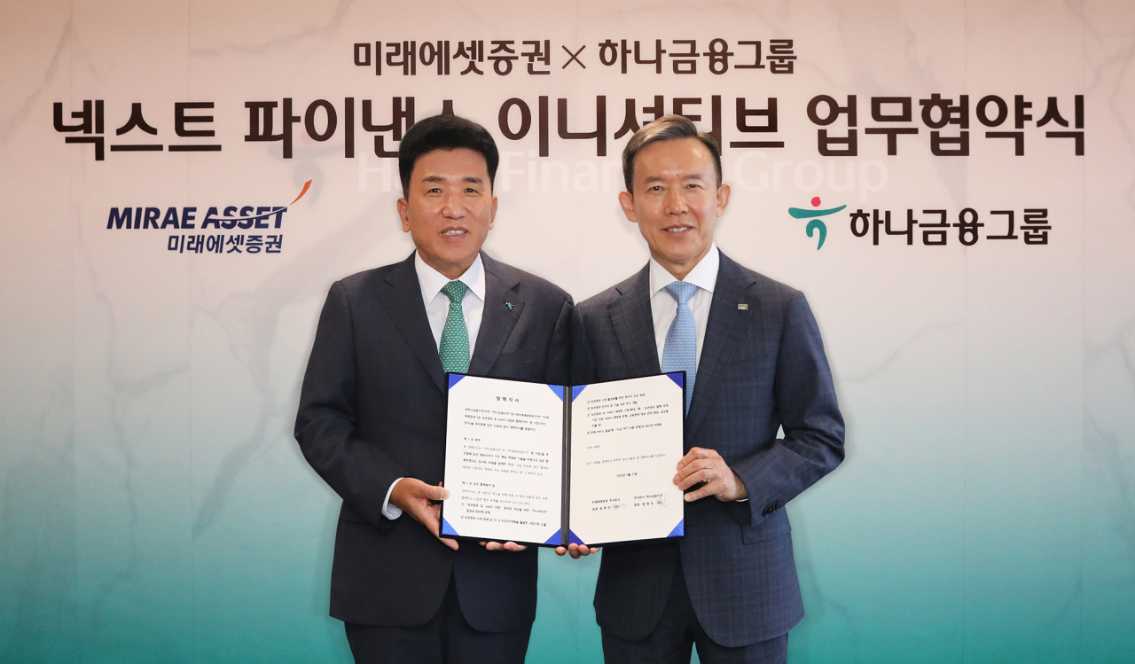 Hana Financial Group Chairman Ham Young-joo (left) and Mirae Asset Securities Chairman Choi Hyun-man pose for a photo during a signing ceremony in Seoul, Thursday. (Hana Financial Group)