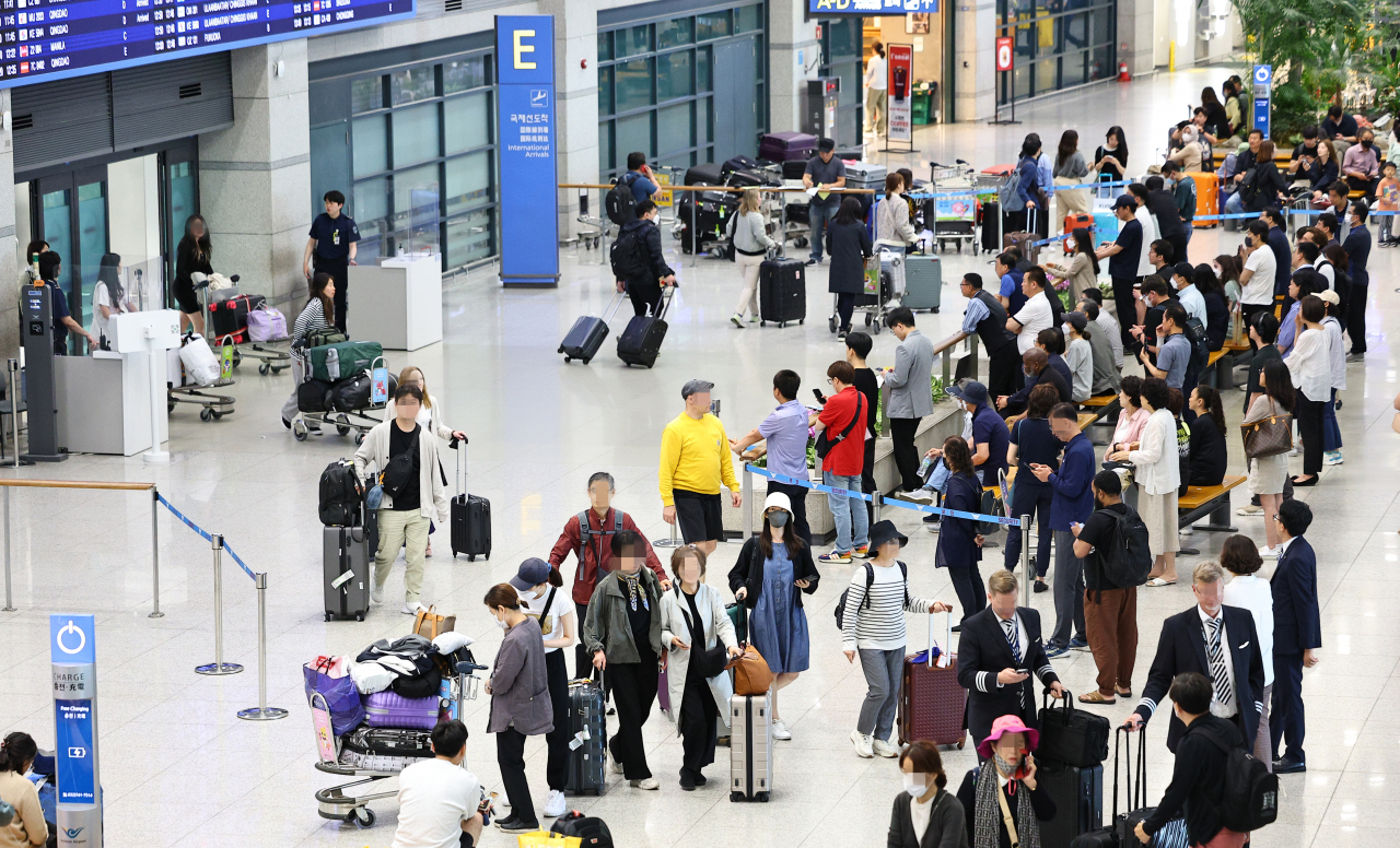 This photo taken Thursday, shows outbound passengers at Incheon International Airport, west of Seoul, as almost all pandemic-related restrictions were lifted the same day. (Yonhap)