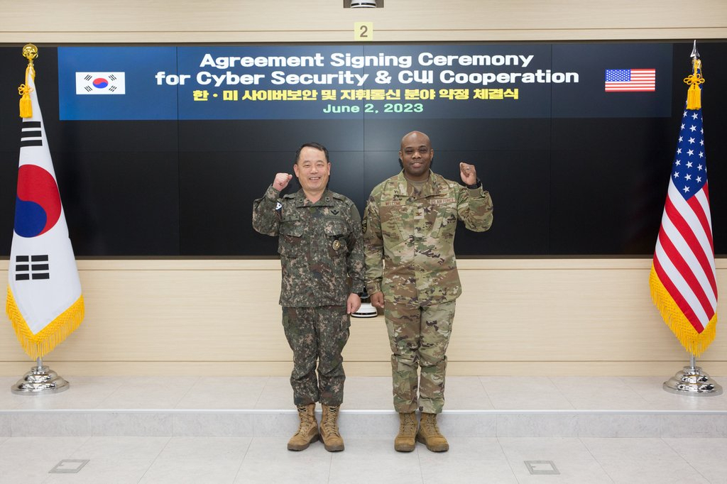 Brig. Gen. Ryu Seung-ha (left) of South Korea's Joint Chiefs of Staff and Col. Erick O. Welcome of the US Forces Korea pose for a photo after signing an arrangement on the creation of the allies' first joint cybersecurity guidance at the JCS headquarters in Seoul Friday. (Ministry of National Defense)