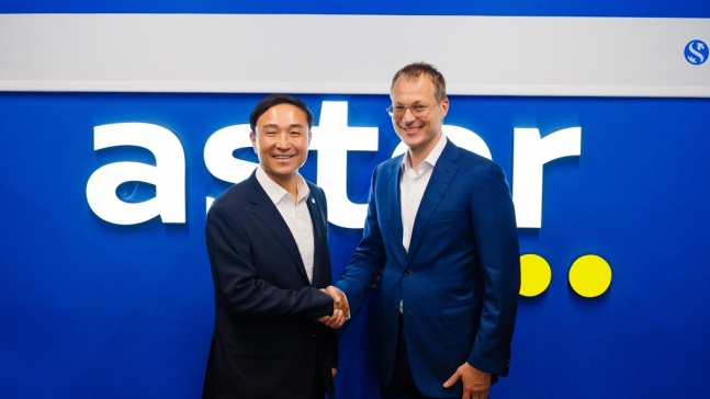 Shinhan Card CEO Moon Dong-kwon (left) poses for a photo with Aster Group Chairperson Alexey Bakal at the Kazakhstan-based conglomerate's headquarters in Almaty, Kazakhstan, Friday. (Shinhan Card)