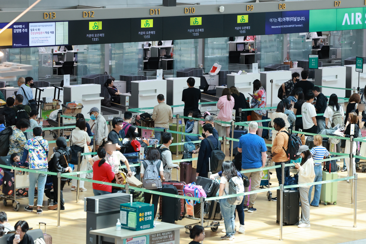 Travelers stand in line in front of a check-in counter at Incheon International Airport, on June 2. (Yonhap)