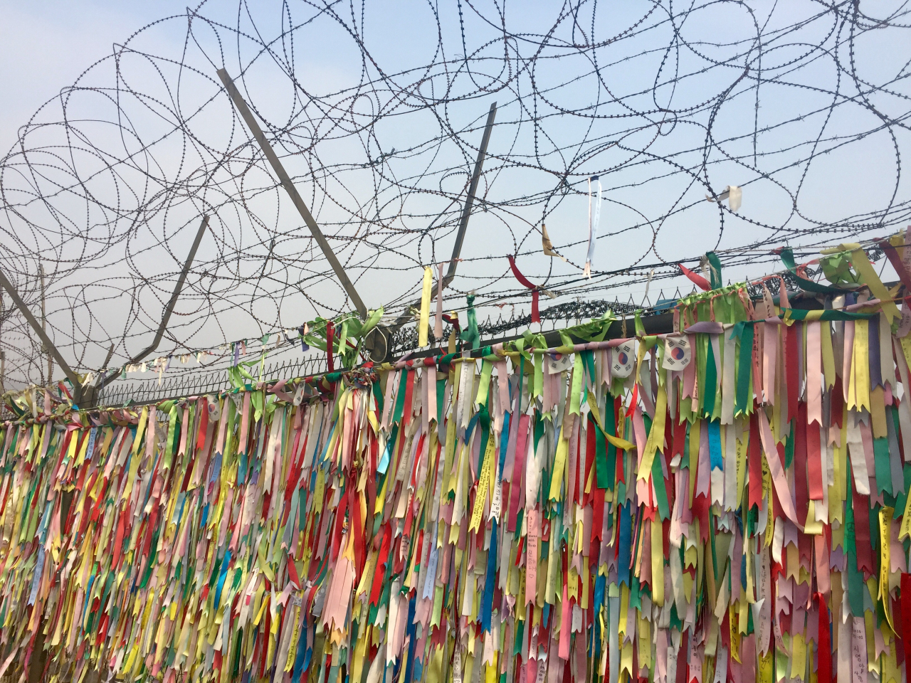The fences surrounding Imjingak Village in the DMZ on the North Korean border are adorned with brightly colored ribbons. These ribbons frequently bear messages of peace, prayers, and well-wishes for family members residing in North Korea. (Photo Courtesy of anokarina's Flicker)
