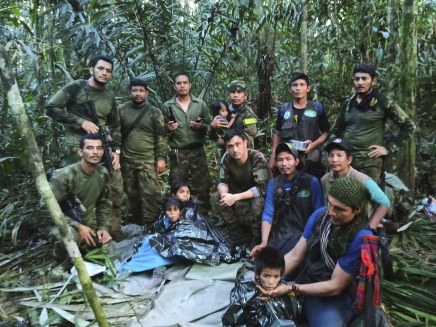 In this photo released by Colombia's Armed Forces Press Office, soldiers and Indigenous men pose for a photo with the four Indigenous children who were missing after a deadly plane crash, in the Solano jungle, Caqueta state, Colombia, Friday. (AP-Yonhap)