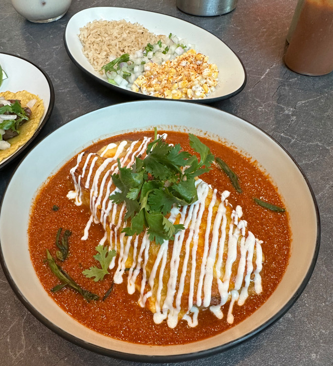 El Pino 323's beef brisket enchilada is served with a side of rice, onions, cilantro and elote creamed corn. (Ali Abbot/The Korea Herald)