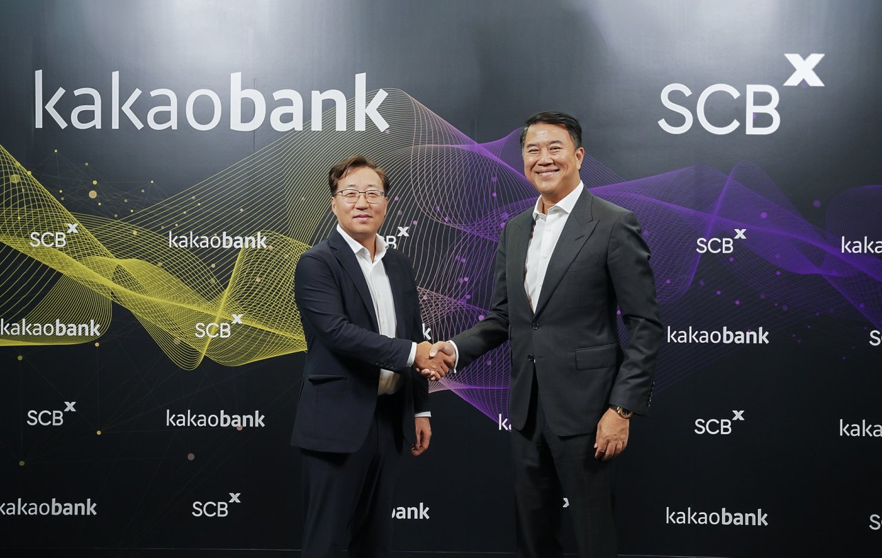 KakaoBank CEO Yun Ho-young (left) and Arthid Nanthawithaya, CEO of SCBX, pose for a photo after signing a memorandum of understanding to pursue a virtual bank license together at SCBX headquarters in Bangkok. (KakaoBank)