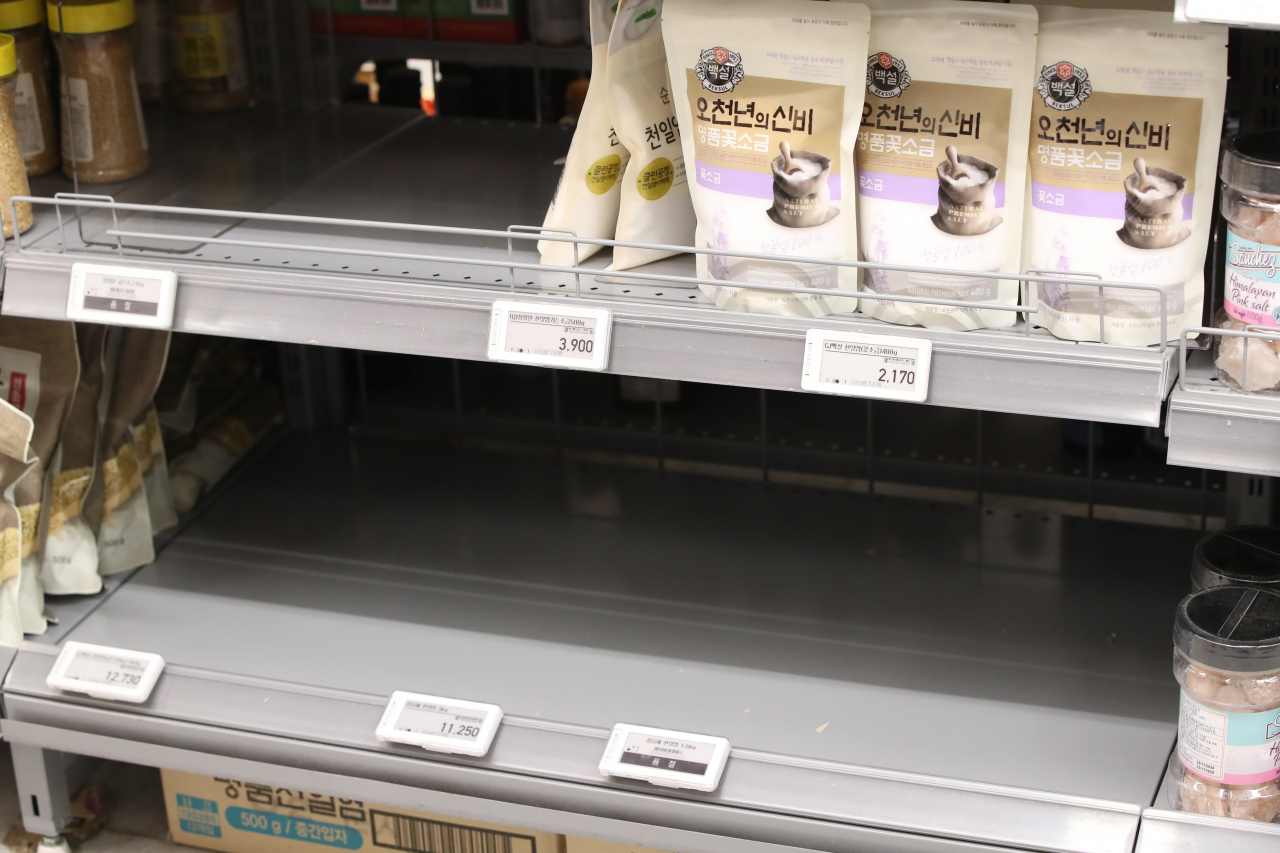 Shelves carrying salt products are left half empty at a discount store in Seo-gu, Daejeon, on Wednesday. (Yonhap)