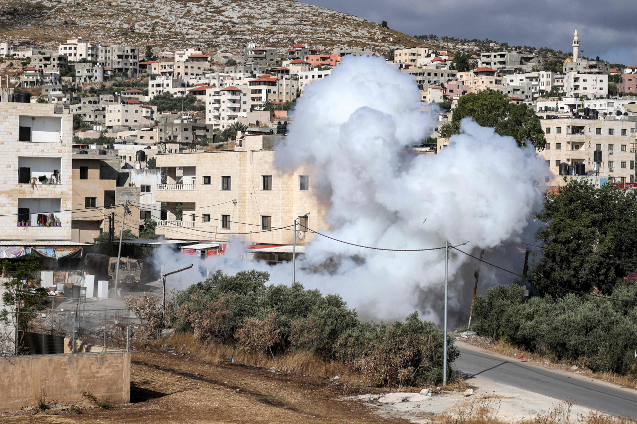 Smoke erupts from the detonation of an explosive charge left by Palestinians along a road during an Israeli army raid in Jenin in the occupied West Bank on Monday. (AFP)