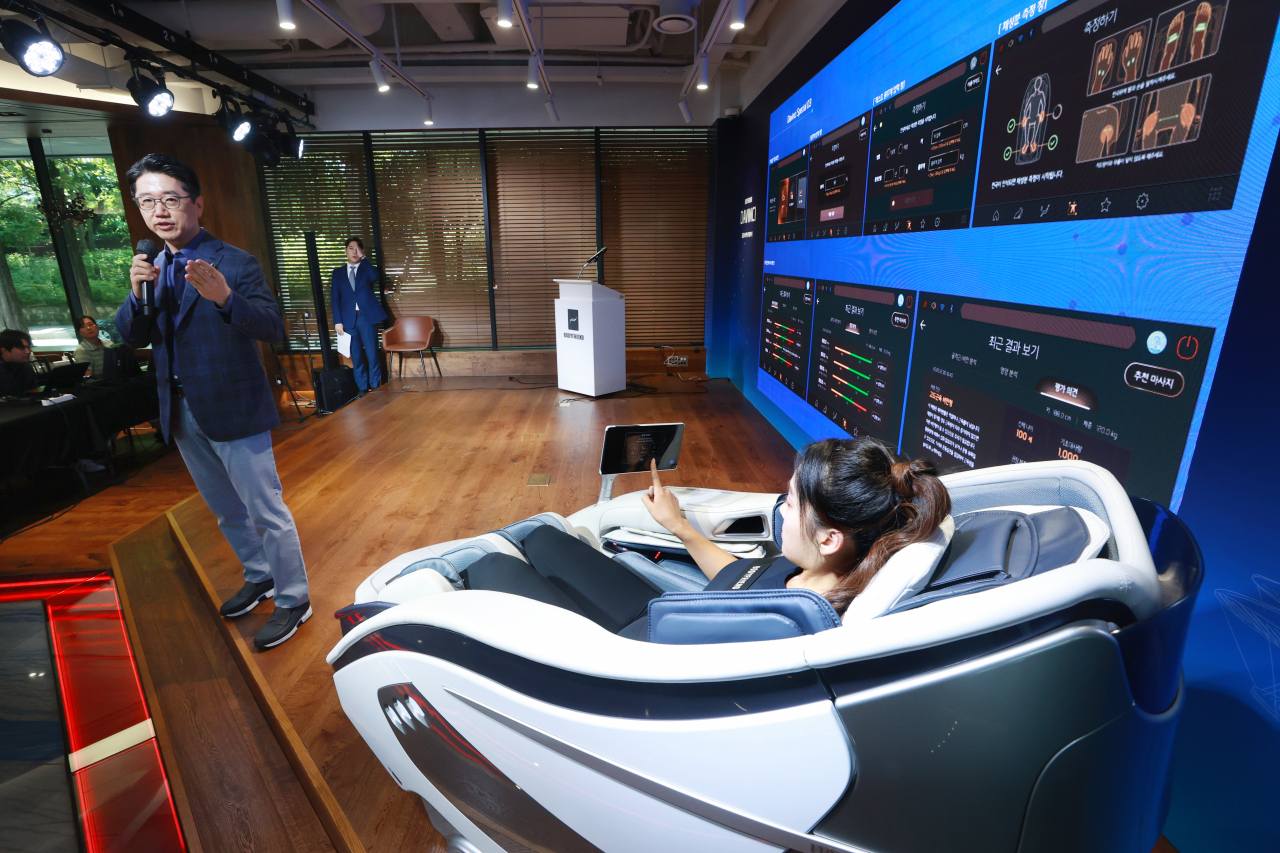 Cho Soo-hyun (left), executive director of Bodyfriend Healthcare Medical R&D Center, gives a presentation on the company’s new massage chair Davinci at a press event held in Seoul on Thursday. (Yonhap)