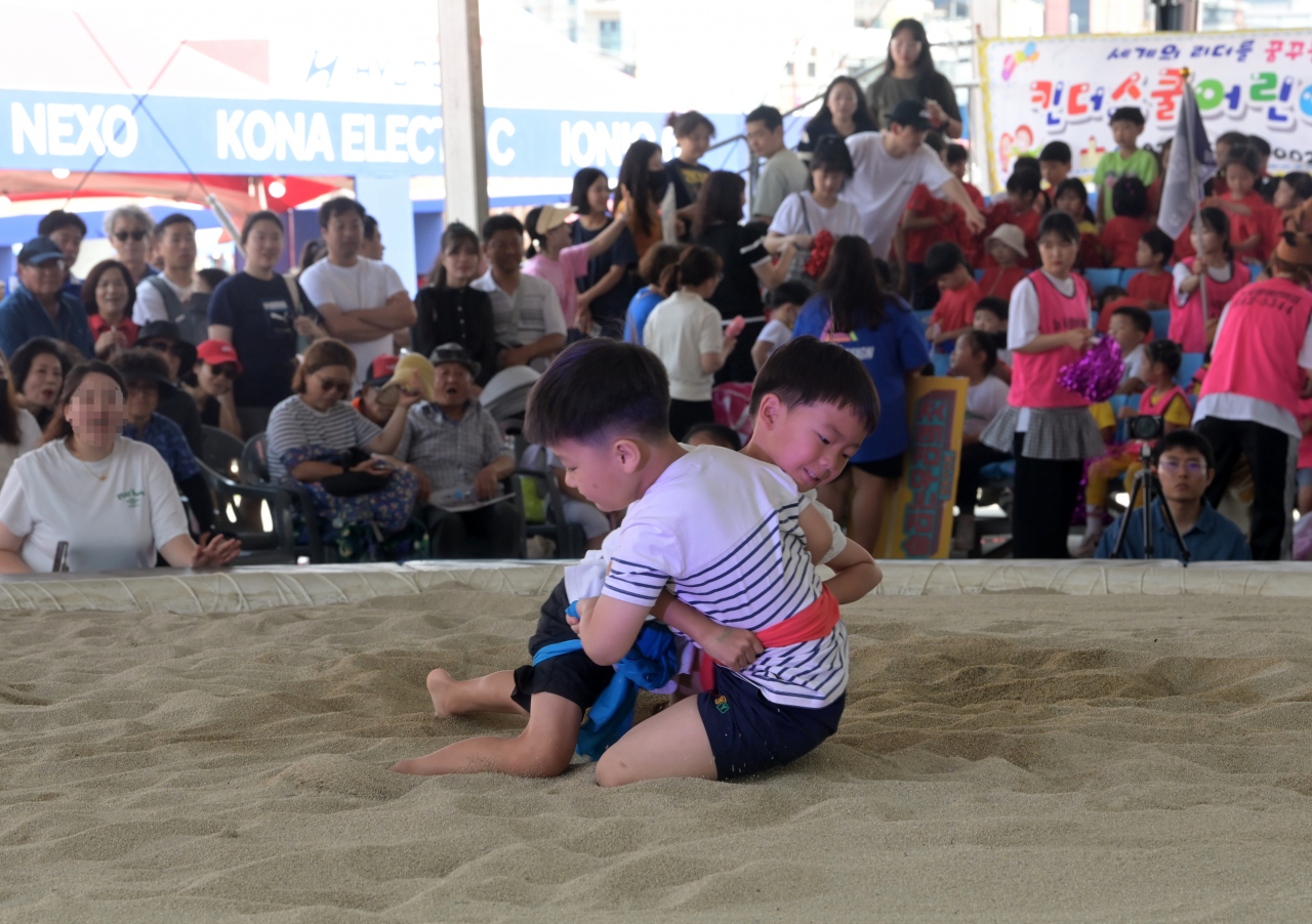 Children participate in traditional Korean wrestling, one of the folk games of the Gangneung Danoje Festival, on June 19 at Nammdaecheon Danojang in Gangneung, Gangwon Province. (Yonhap)